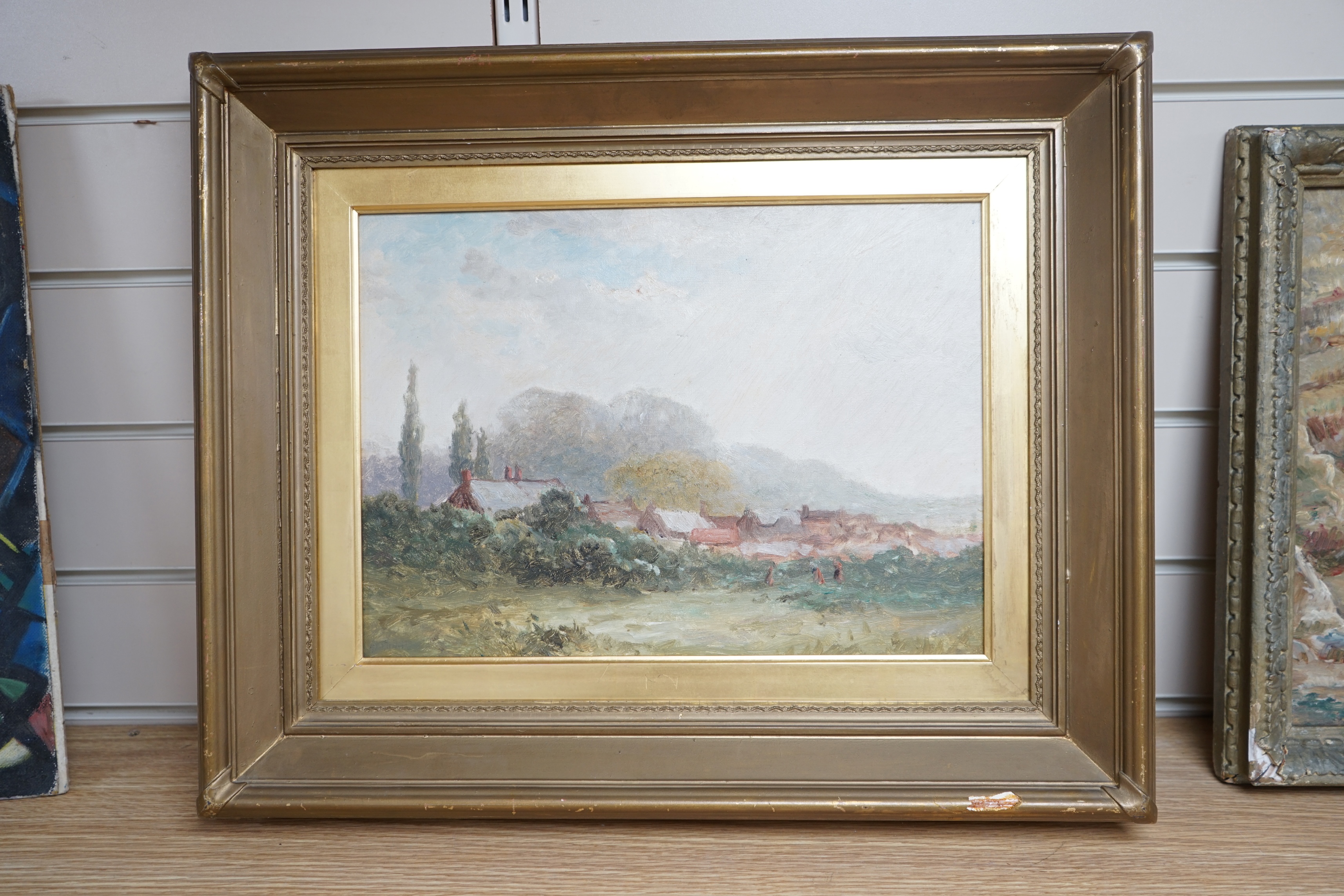 Late 19th century, English school, oil on canvas, View of a village across fields, unsigned, 26 x 36cm, gilt framed. Condition - fair to good